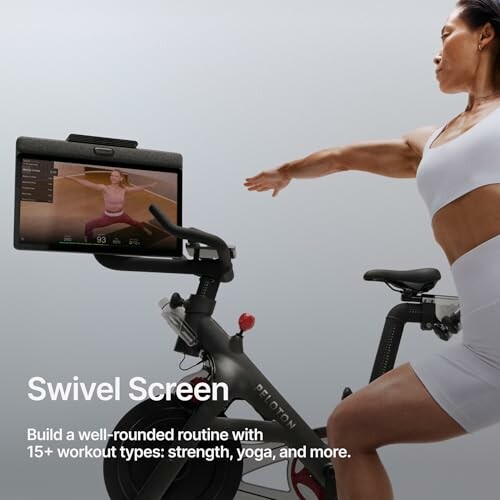 Person using an exercise bike with a swivel screen displaying a workout.
