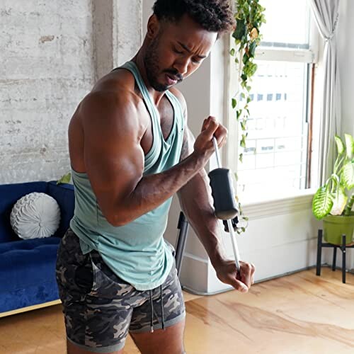 Man in gym attire exercising with resistance equipment at home